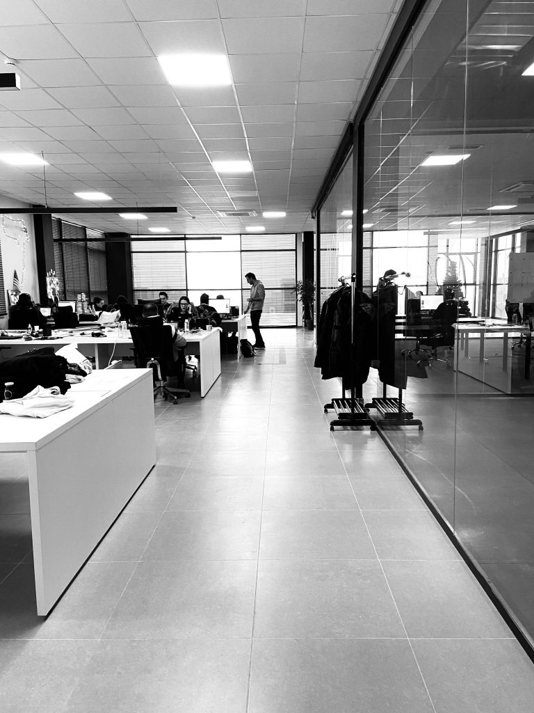 Black and white of anonymous employees working together in modern office with glass walls